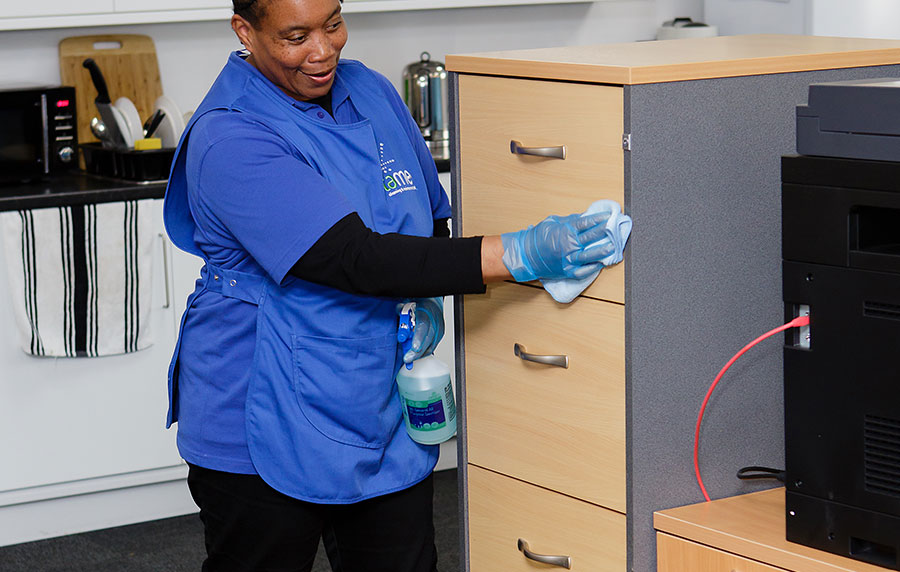 Commercial Office Cleaning in Birmingham, Tame staff cleaning office cabinets by hand